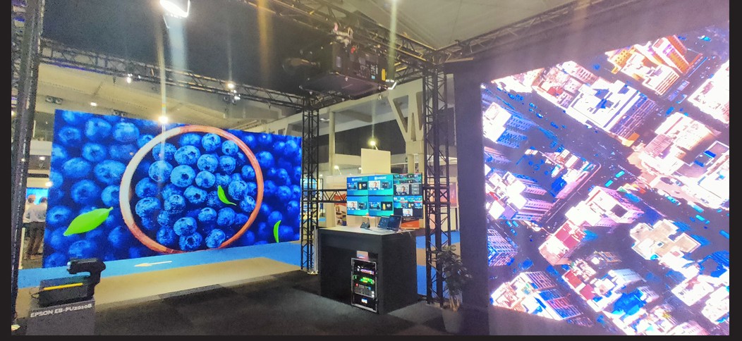 A projection surface beside a direct-view LED wall at a trade show