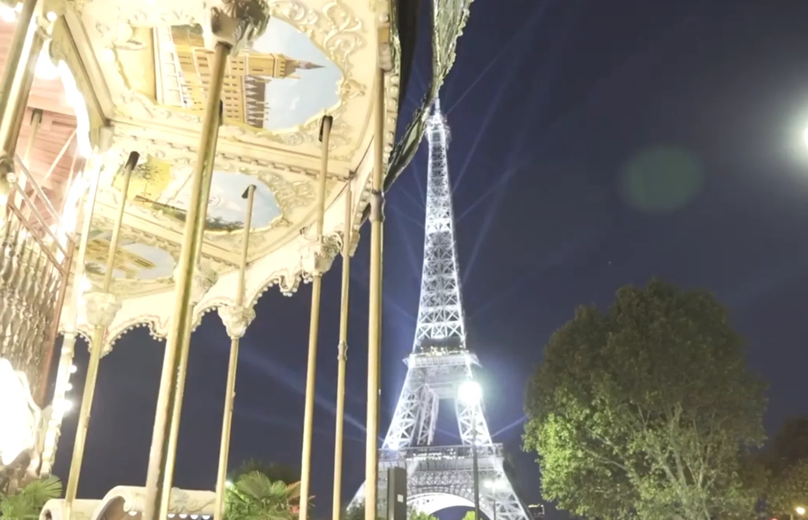 Searchlights sweeping over Paris from the Eiffel Tower during the show.