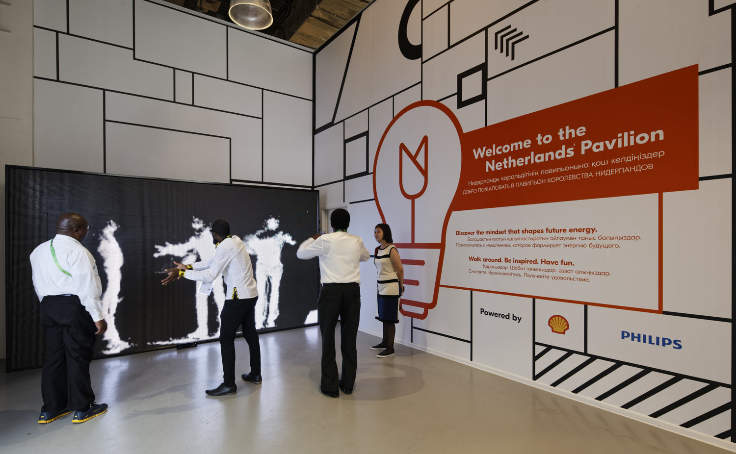 The bright entrance of the pavilion: white walls, black linework, and a red tulip-bulb welcome graphic