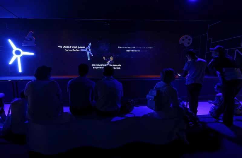 The holographic main show of the Netherlands Pavilion, an audience in deep blue light