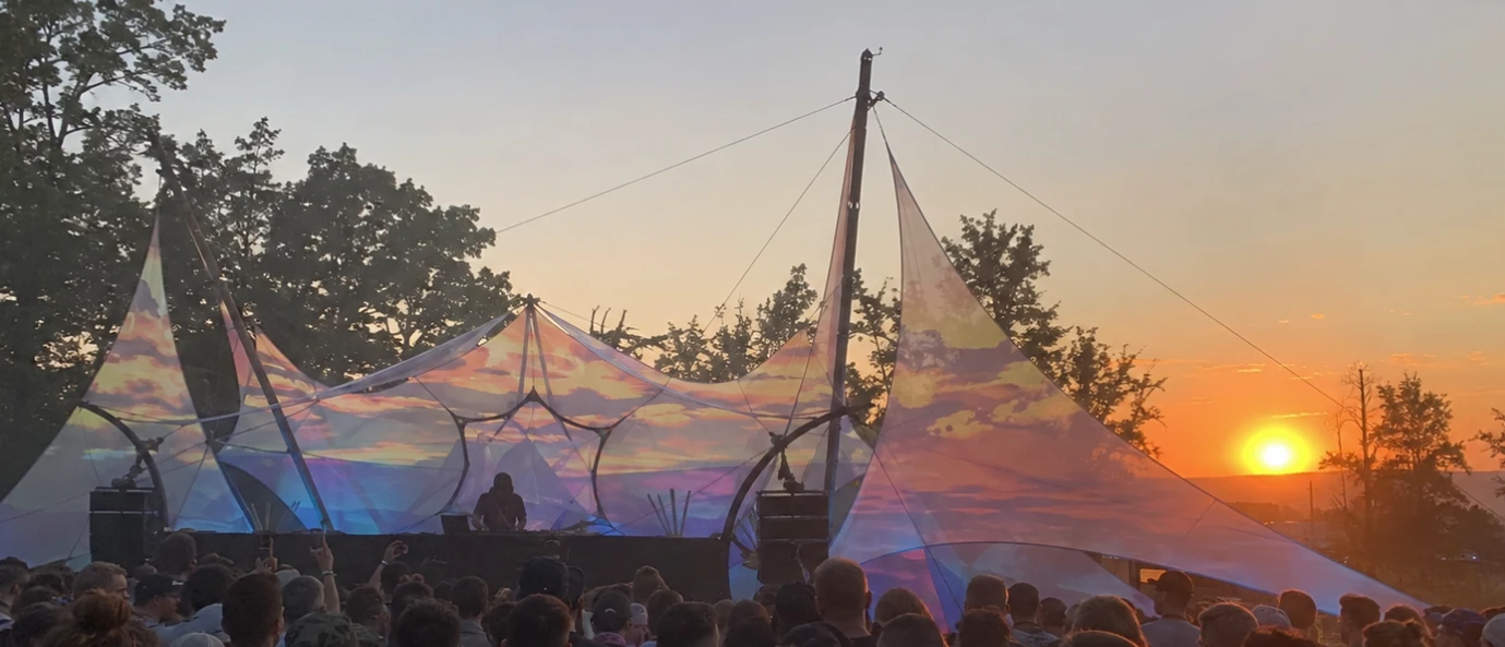 The Sunrise Set · projected sky on the sail canopies as the real sun clears the treeline