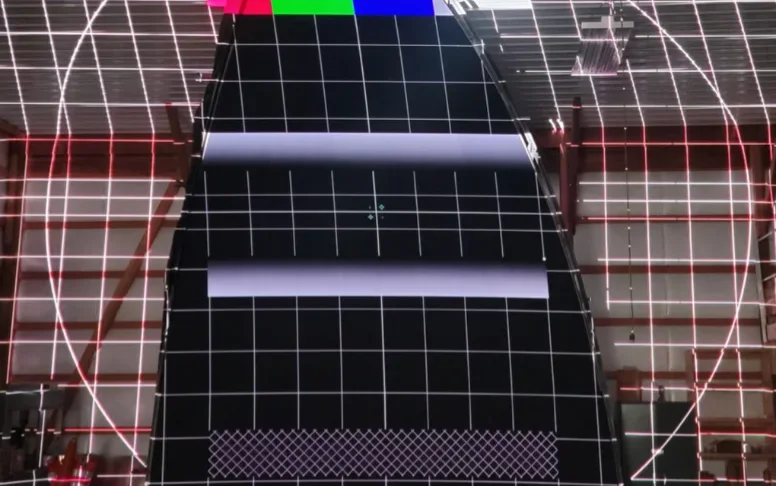 A shaped, tensioned fabric projection canvas under moving content.