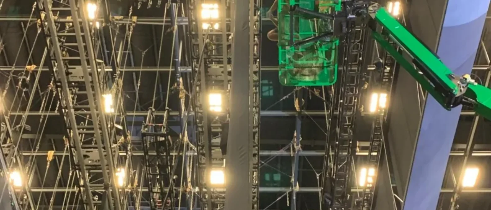 Morning technical check: an empty hall with house lights up, one technician walking the canvas.
