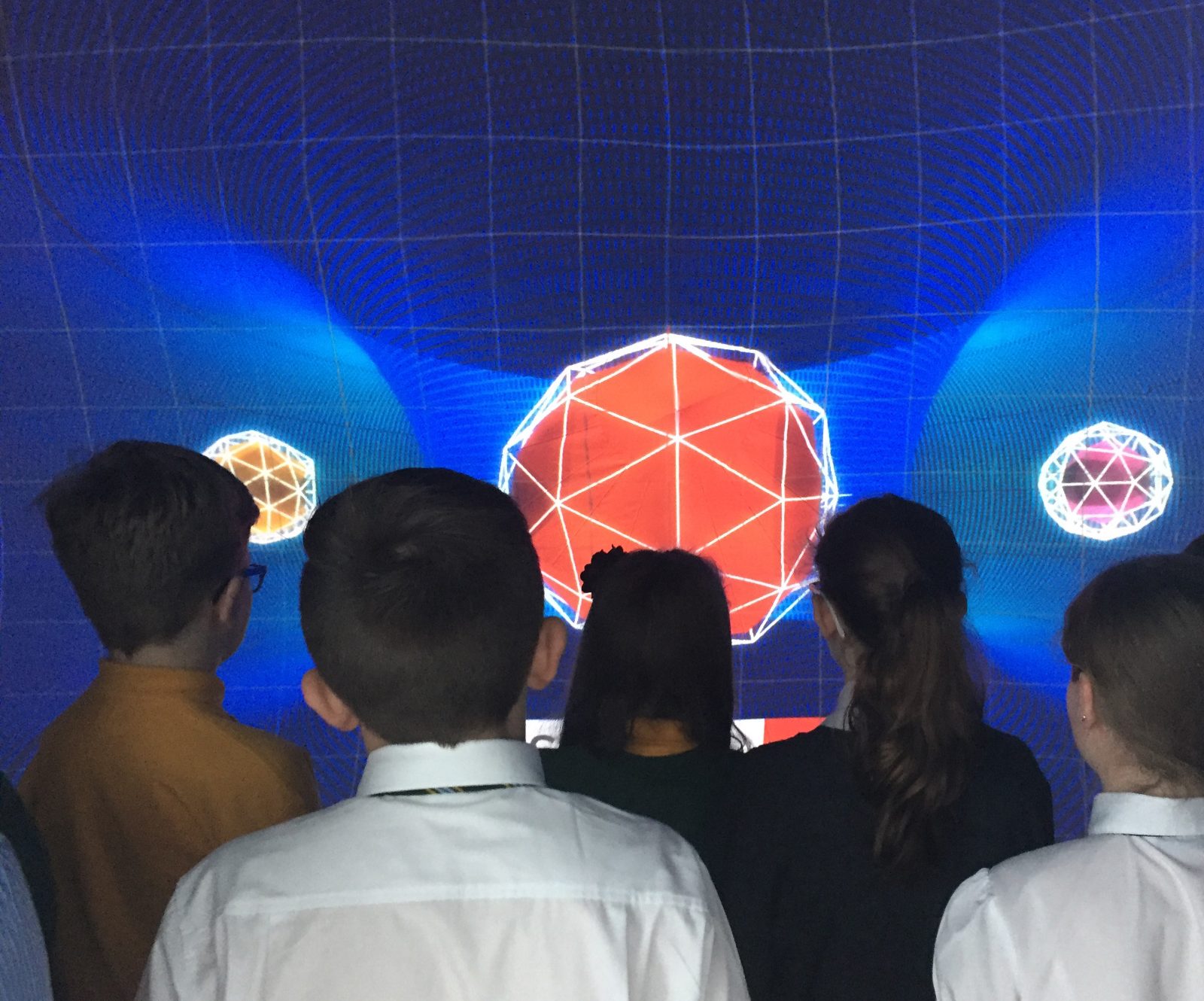 Students gathered around interactive geometry inside a dome classroom