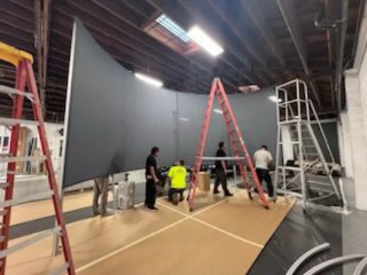 A curved projection screen fifty feet wide showing a night sky, with atmospherics sweeping across it like weather.