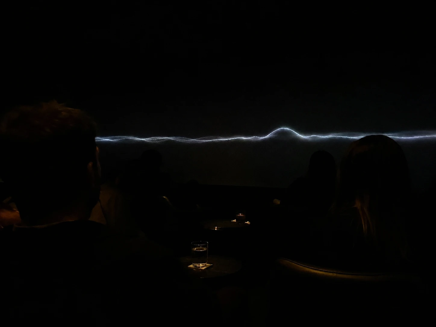 Umbra · the sound horizon breathing along the wall over guests in darkness